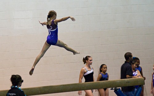 Kaili Yuen, of the Kona Aerials, performs a leap on the beam. (Photo by Susan Dabritz/SeaPics.com)