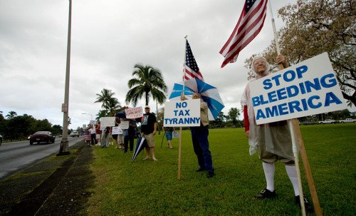 Over a hundred people wave signs and flags in Hilo for the Tax Day Tea Party demonstration. Photography by Baron Sekiya/Hawaii247.com