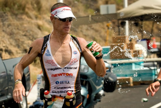 Craig Alexander goes for hydration on the marathon course of the Ironman Triathlon. Heat and humidity are taking their toll on runners. Photography by Baron Sekiya for Hawaii 24/7.