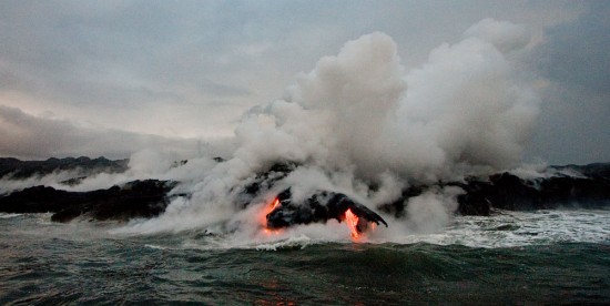 Steam rises from lava flows cascading down the Waikupanaha entry point west of Kalapana.