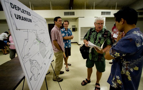 Jim Albertini, center, talks to Russell Okoji, consultant with the Saddle Road project, about his depleted uranium concerns with the Saddle Road project.