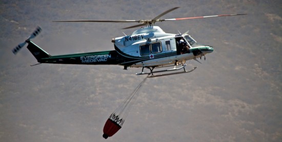 A chartered helicopter comes in to pick-up water near Saddle Road to drop onto the fire on the slopes of Mauna Kea.