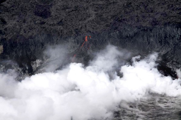 One of the individual streams of lava cascading over the sea cliff, producing a thick steam plume at the waterâs edge. Photo courtesy of USGS/HVO