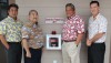 Toby Taniguchi and Barry Taniguchi of KTA Super Stores, Mayor Billy Kenoi, and Bobby Command of the County stand with one of the new AEDs donated by the Taniguchis.