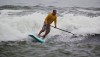 A stand-up paddleboarder catches a wave in Hilo Bay Saturday afternoon (March 10). Photography by Baron Sekiya | Hawaii 24/7