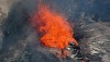 The spatter from the lava lake was landing, in part, on the ledge adjacent to the lake, and then flowing away in a small channel toward the southern side of the vent where it was ponding and cooling. Notice the wrinkled crust on the surface of the lake. Photo courtesy of USGS/HVO