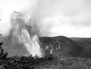 Hawaii Volcanoes National Park. 1959 eruption of Kilauea Volcano, third phase of activity in Kilauea Iki Crater. Reduced fountain deflected northward by the collapse of the inner part of the cone in the crater. Note the new cone developing on the left shoulder of the old main cone (immediately to the right of the fountain). View is from the trail leading down to Byron Ledge. 8:00 a.m., November 29, 1959. Photo courtesy of USGS