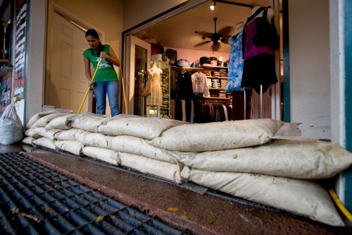 20081211_honolua-wahine Tiere Ubando sweeps debris from Honolua Wahine, at the Kona Inn Shopping Center on Alii Drive, after rainstorms and street flooding occurred Thursday afternoon. Shopping center crews sandbagged the entrance to prevent flooding into the shop.