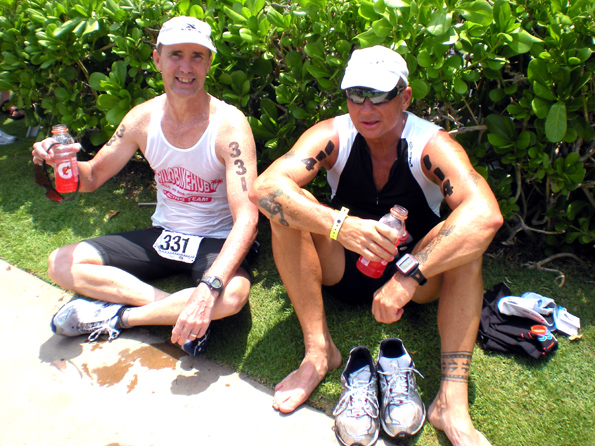 703refreshments Adam Busek, 47, of Keaau, and Bill Greineisen, 56, of Volcano, relax and enjoy some post-race refreshments. (Hawaii247.com photo by Karin Stanton)