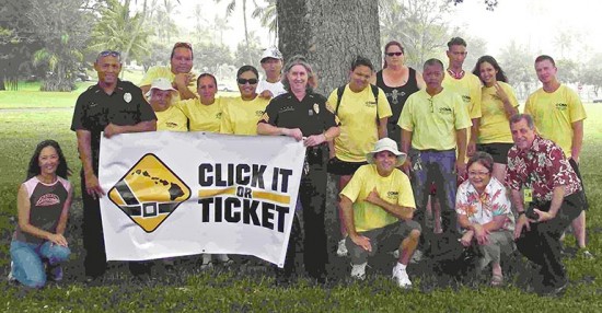 click_it_large Community Police Officer Todd Pataray and Sergeant Kelly Ka'aumoana-Matsumoto hold a "Click It or Ticket" sign with community volunteers, who helped kick off this year's campaign with a sign-waving event Monday.