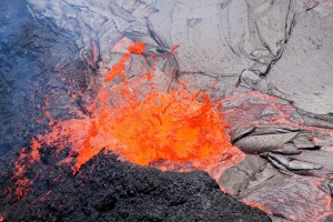 20110623_Puu-Oo-Lava-Lake-Spatter Low-level spattering from points wandering around the perimeter of the lava lake continually builds up the levee that impounds the lake. Photo courtesy of USGS/HVO