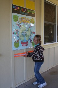 IMG_5943 3rd grader Jenna Blevins affixes on "The Road to a Greener Planet," the sticker she earned for biking to school.