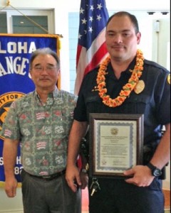 Aloha Exchange Club President Jay Kimura presents an 'Officer of the Month' plaque to Sergeant James Correa.