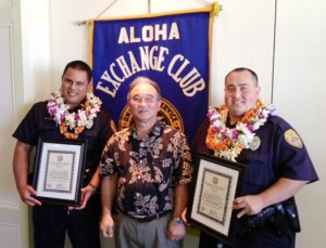 Aloha Exchange Club President Jay Kimura presents an 'Officer of the Month' plaque to Officers Murray Toledo and Luke Watkins