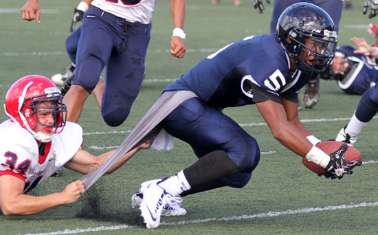Keaau's Matthew Winters holds on Kamehameha's Shaun Kagawa's shirt to make a tackle during BIIF action. (Photo courtesy of Tim Wright