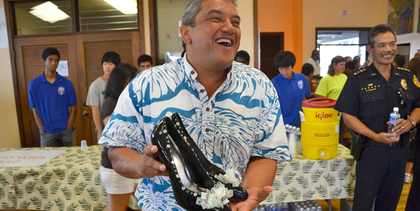 Mayor Billy Kenoi selects a pair of heels for the 2012 Walk-a-Mile event. (Photo courtesy of YWCA Hawaii Island)