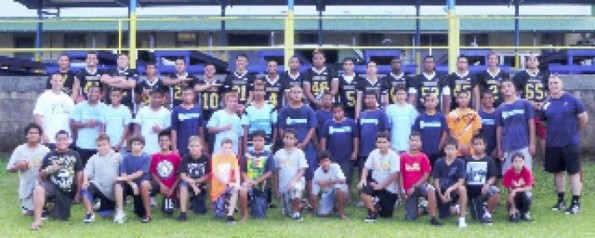 Front row: elementary students. Middle row: Officer Tina (far left), intermediate students and Officer Botelho (far right). Back row: Coach Baldwin (far left) and his Hilo High School football players.
