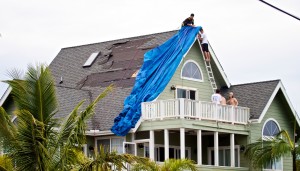 Residents in Hawaiian Paradise Park in Puna work to cover damaged portions of a roof torn away by Tropical Storm Iselle. Photography by Baron Sekiya | Hawaii 24/7