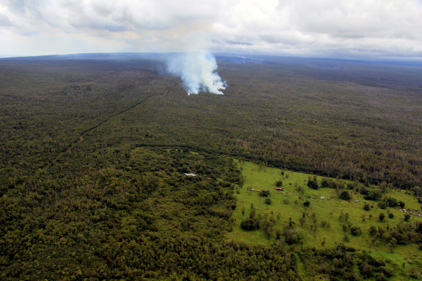 The June 27th lava flow remains active, with lava at the flow front issuing from a ground crack and advancing through thick forest, creating dense plumes of smoke. The farthest lava this afternoon was 13.2 km (8.2 miles) from the vent on Puʻu ʻŌʻō, and 1.3 km (0.8 miles) from the eastern boundary of the Wao Kele o Puna forest reserve. This forest reserve boundary is at the western boundary of Kaohe Homesteads subdivision, a portion of which is visible at the bottom of the photograph. Photo taken Wednesday, September 3, 2014 courtesy of USGS/HVO