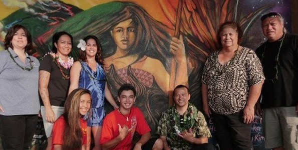 Mele Murals Creative Director Estria Miyashiro (kneeling, right) and students Kayla Cagampang and Kawika Lawrence showcase a mural depicting the battle of Kuamo‘o. Standing are: KS West HI Support Services Manager Deeann Haberly, Mele Murals Project Coordinator Mahea Akau, KS Curriculum and Assessment Coordinator Kanakolu Noa, cultural advisor Kalani Hamm and KS Cultural Resource Specialist Mahealani Pai. (Photo courtesy of Mele Murals)