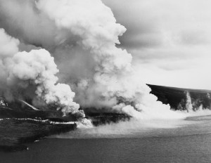 Two of three lava flows that raced down the southwest slope of Mauna Loa on June 2, 1950, are shown here. As lava entered the ocean, steaming water marked its offshore course. A semicircular area of hot, turbulent water killed many fish that were seen drifting on currents or washing up on shore over the next few days. Photo courtesy of U.S. Air Force.