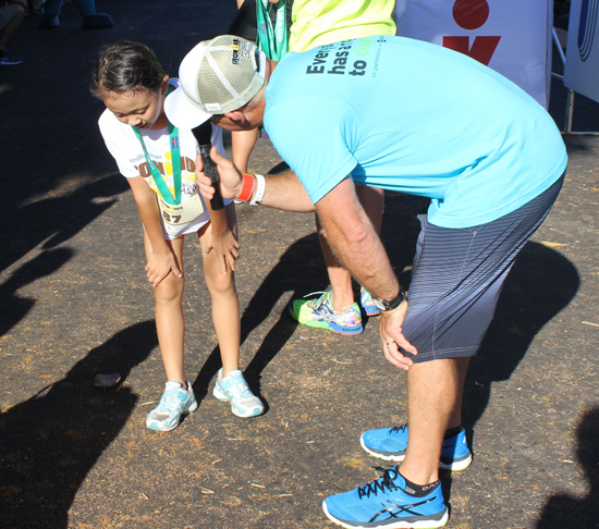 Former world champion Greg Welch interviews a young athlete after the Keiki Dip-n-Dash. (Hawaii 24/7 photo by Karin Stanton)
