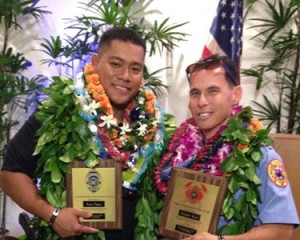 Police Officer Ryan Pagan and Fire Captain Garrett Kim display plaques from the Aloha Exchange Club of East Hawaiʻi.