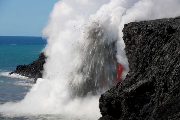 As seen in late January, the interaction of molten lava and cold seawater at the Kamokuna ocean entry produces an explosion, sending hot fragments and steam high into the air. The sea cliff in this image is about 15 meters (50 feet) high. USGS photo.