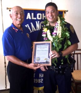 Aloha Exchange Club board member Joey Estrella presents an 'Officer of the Month' award to Officer Thomas Chun-Ming