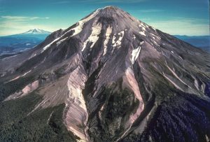 Before the eruption of May 18, 1980, Mount St. Helens’ elevation was 2,950 m (9,677 ft). View from the west, Mount Adams in the distance. S. Fork Toutle River is the valley in the center of the photo. Photo taken 1979 courtesy of USGS.