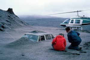 USGS geologist Don Swanson (in red) and his colleague, Jim Moore, view a car filled with ash deposits from the May 18, 1980, eruption of Mount St. Helens.