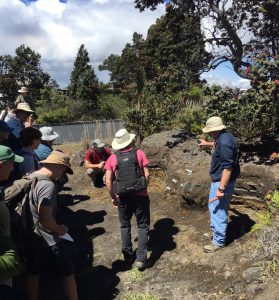 USGS geologist Don Swanson (right) explains Keanakāko‘i Tephra stratigraphy exposed near the Hawaiian Volcano Observatory to scientists who visited Kīlauea during a Geological Society of America field trip in May 2017. USGS photo by T. Neal.