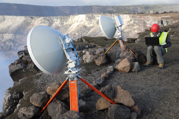Dr. Nial Peters from the University of Cambridge sets up the prototype radar on the rim of Halema‘uma‘u at the summit of Kīlauea in January 2018. Microwave pulses are transmitted from one dish towards the lava lake surface. Some of the microwave energy is reflected back and is received by the other dish. The range or distance to the lava lake is then calculated from the time taken between transmission and reception of the pulses, providing a sensitive measure of the lava lake height. Measurements can be made continuously. Photo courtesy of C. Oppenheimer.