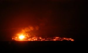 On Tuesday night (April 24), between around 8:30 p.m. and 11:00 p.m., Kīlauea Volcano's summit lava lake overflowed once again. This photo, taken around 10:30 p.m., shows the large overflow as it spread west (to the right) from the lava lake onto the floor of Halema‘uma‘u. The bright (yellow-white) spot is spattering along the south margin of the lava lake. USGS photo by M. Patrick. Photo taken Tuesday, April 24, 2018 courtesy of U.S. Geological Survey