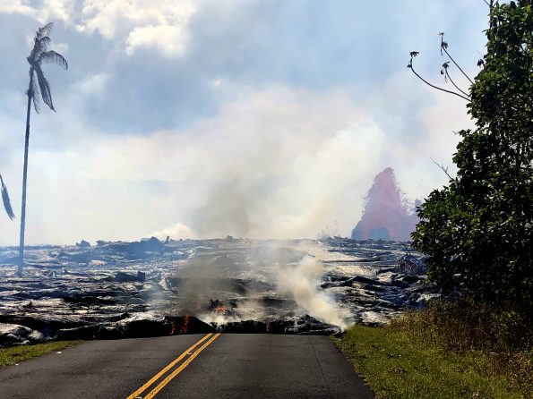 Pāhoehoe lava advancing west from fissure 7 (lava fountain in background) on Leilani Avenue. Fissure 7 activity increased overnight, with lava fountains reaching 50 to 60 m (164 to 197 ft) high. Photo taken Sunday, May 27, 2018 courtesy of U.S. Geological Survey