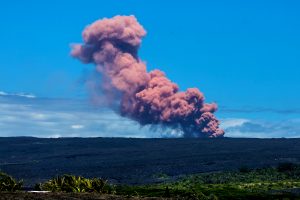 A 5.0 magnitude earthquake around 10:31 a.m. Thursday, May 3, 2018 triggering a small collapse at Pu‘u Ō‘ō vent that sent a rose-colored plume billowing skyward. The plume was visible throughout Hawaii Volcanoes National Park and neighboring communities, including Kalapana Gardens, where this photo was taken. NPS photo by Janice Wei