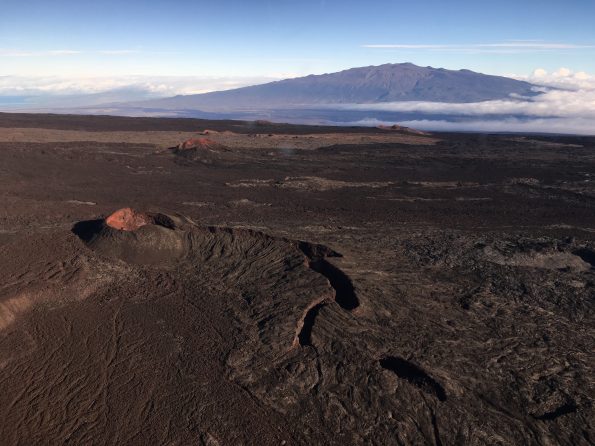 View of cinder cones in the Northeast Rift Zone near the summit of Mauna Loa. View to the north-northeast with Mauna Kea in the background. Mauna Loa has erupted 33 times since 1843, most recently erupting in 1975 and 1984. Photo credit: Matt Patrick, USGS